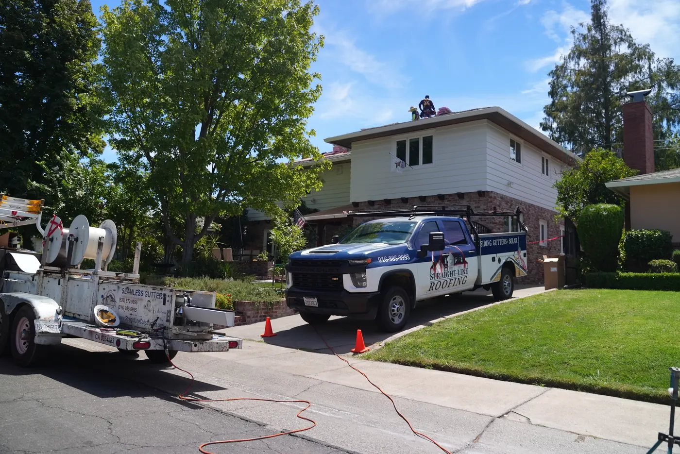 A Straight Line truck and trailer set up outside a home before work begins
