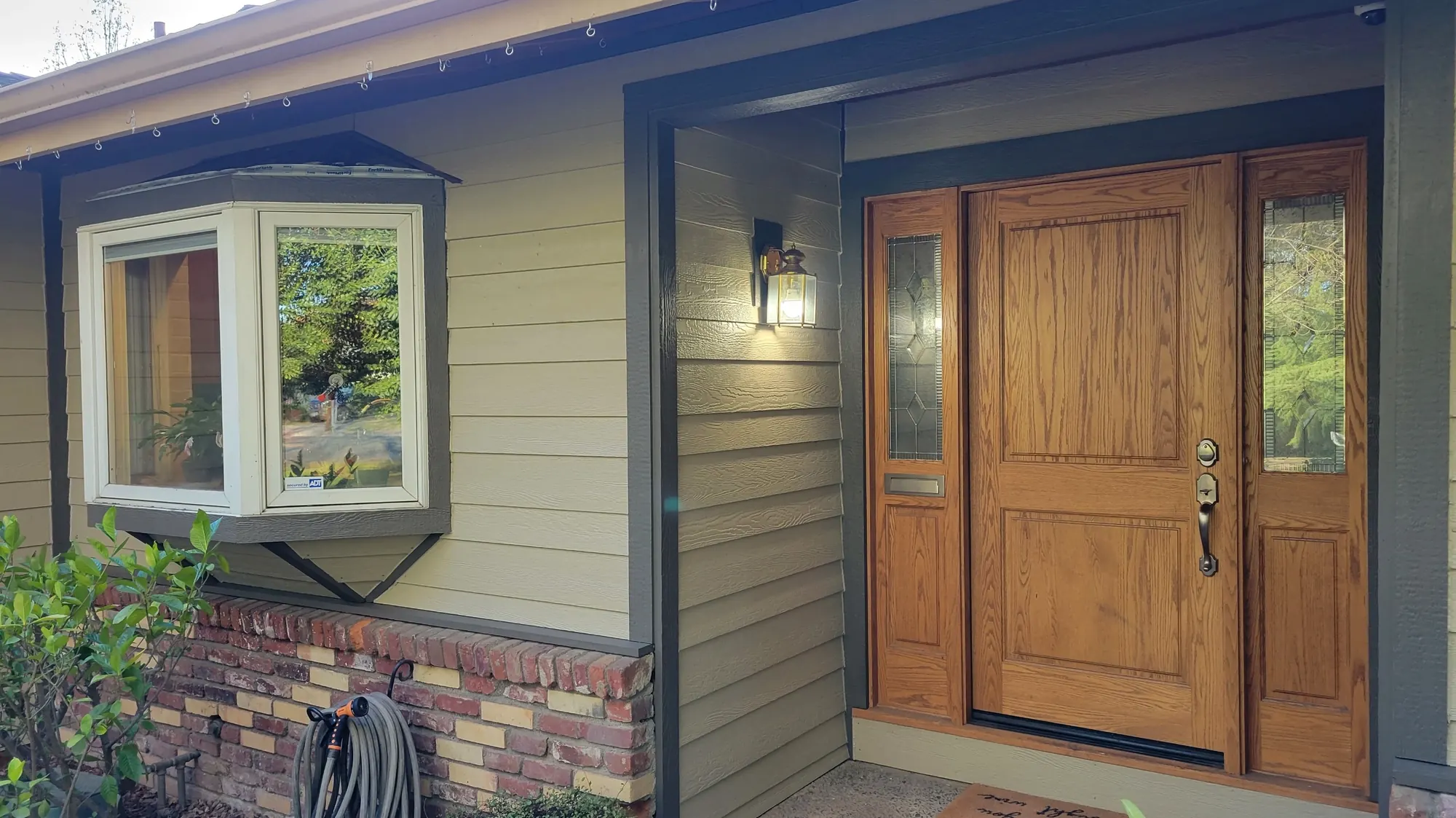 A bay window and entry on a home finished by Straight Line Roofing and Construction