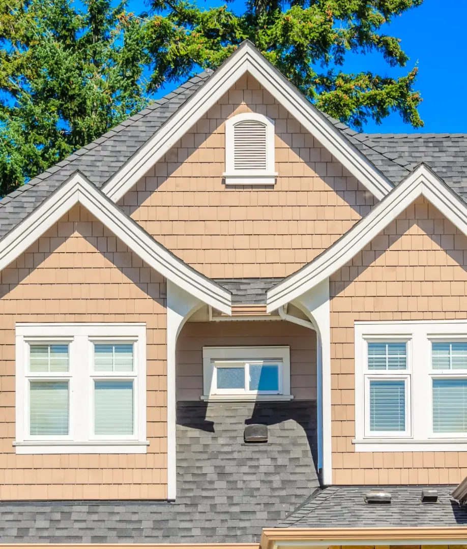 A bay window with trim and siding on a finished home exterior