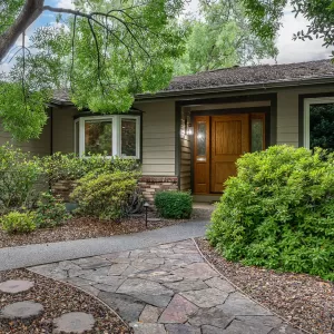 Walkway surrounded by landscaping that shows coordinated design with the roof and siding on a home.